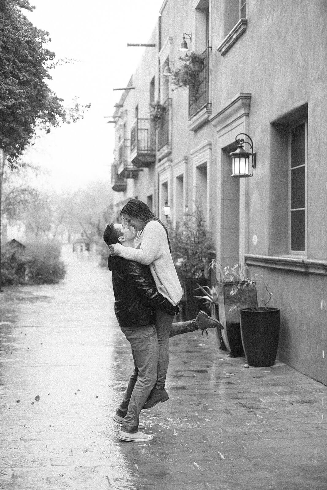 what if it rains on my wedding day? A black and white image of a couple kissing in the rain