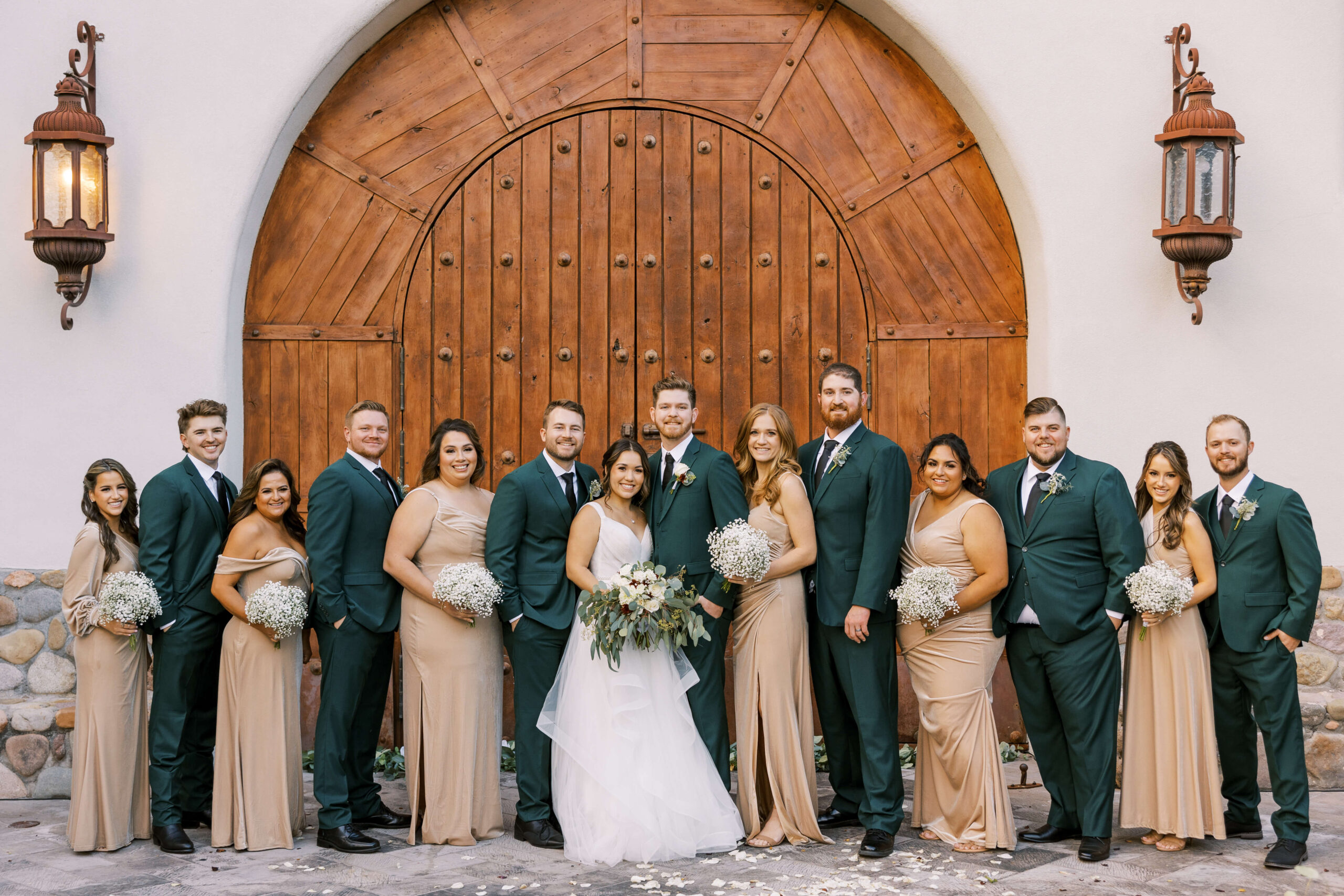 Wedding party in champagne gowns and green suits standing in front of the wedding chapel at tubac golf resort
